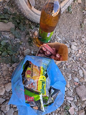 Ein mit Süssigkeiten gefüllter blauer Sack steht auf dem Boden.