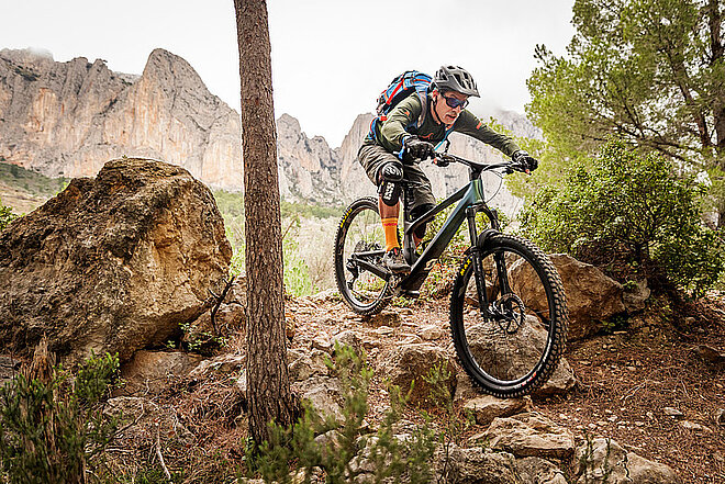 Ein Mountainbiker fährt auf einem Biketrail.