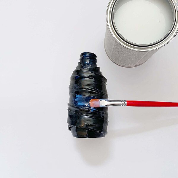 Bild mit einer Flasche, einem Pinsel und einem Topf.