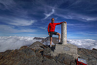 Ein Mann steht auf einer Passhöhe