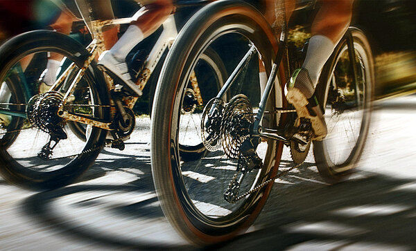 Ein Bild, das Rennradfahrer auf Rennrädern zeigt. 