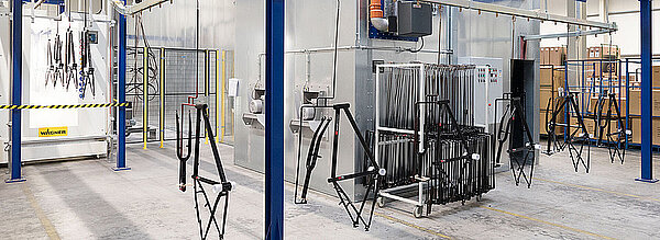 Dutech Holding kauft Prophete und Cycle Union. Fahrradrahmen hängen in einer Lackierstrasse.