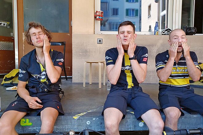 Tipps Sonnenschutz Velofahren. Drei Männer cremen sich das Gesicht mit Sonnencreme ein.