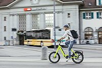 Frau mit Helm auf E-Bike