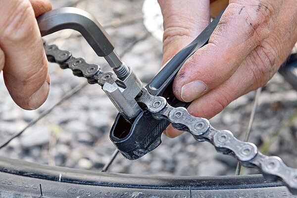 Kettenriss Fahrrad Reparatur. Kettennietendrücker an Fahrradkette.