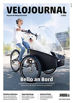 Velojournal 5-2022. Eine Frau mit weissem Shirt fährt ein Lastenrad, imdem vorne ein weisser Wuschelhund sitzt.