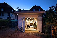 Ein Mann arbeitet in einer Garagenbox an einem Fahrrad.