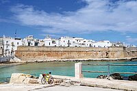 Fahrradreise durch Apulien. Ein Fahrrad steht an einer Meeresbucht,