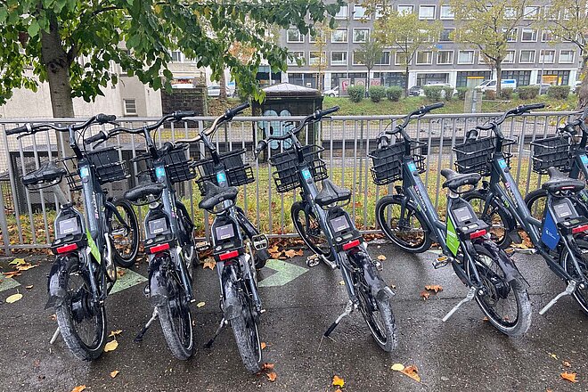Velos stehen nebeneinander auf einem Platz.