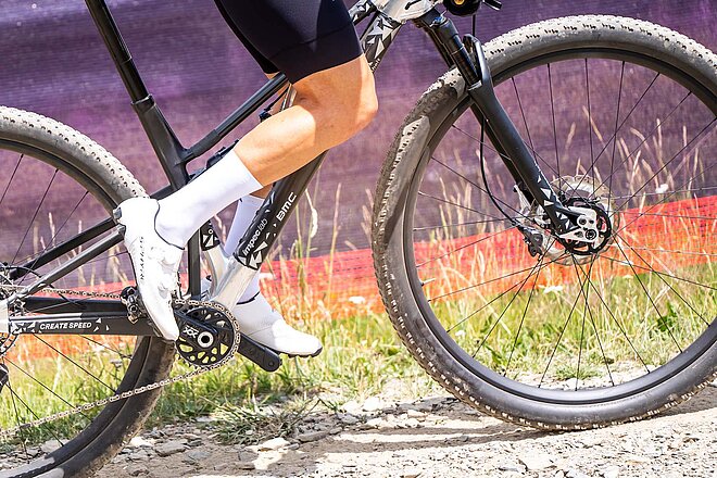 Mountainbiker mit Renndress auf einem Mountainbike.