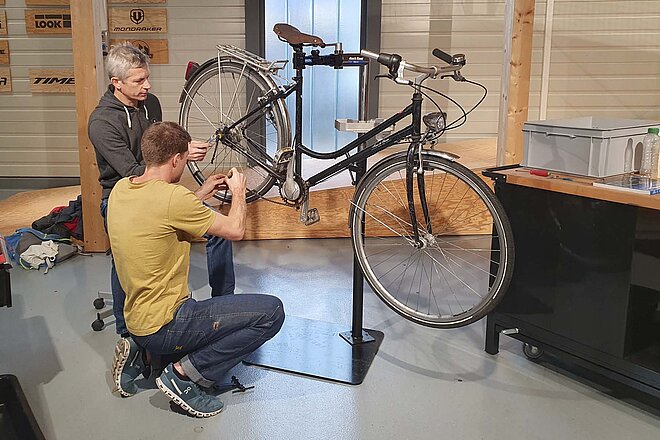 Einstiegskurs für Velowerkstatt-Mitarbeitende. Ein Mann wechselt die Kette an einem Fahrrad.