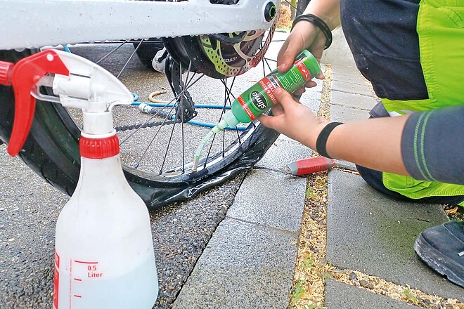 Ohne kompliziertes Ausbauen des Hinterrads: Reifenreparatur mittels Lochdichter. Pannendienste für E-Bikes im Vergleich. Lochdichter wird in einen Reifen eingefüllt.