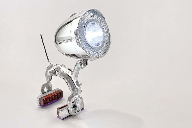 Ergänzt man eine Felgenbremse klug mit einer LED-Velolampe im Retrostyle, erhält man eine tierisch schöne Lichtquelle. Eine Nachttischlampe aus Fahrradteilen.