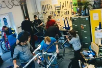 Stundenten und Studentinnen schrauben zusammen an ihren Velos.