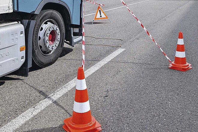 Mit dem LKW den  toten Winkel erleben. Verkehrspylonen stehen auf der Strasse.