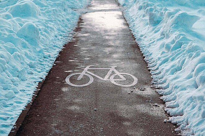 Von Schnee geräumter Radweg.