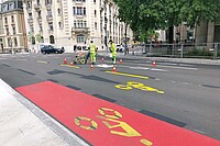 Arbeiter bringen auf einer Strasse in Genf Velowegmarkierungen an