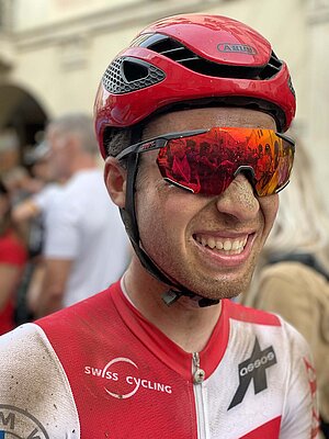 UCI Gravelbike WM 2022. Gravelbiker mit dreckverschmiertem Gesicht. 