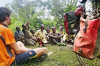Film anderswo, alleine in Afrika. Ein Mann sitzt am Boden auf einer Wiese. 