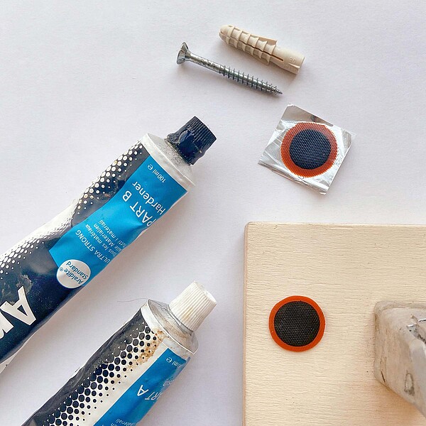 Kleber und Schlauchflicken liegen auf einem Tisch.