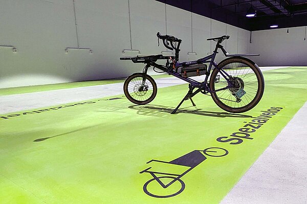 lastenfahrrad steht auf einer grünen Fläche.