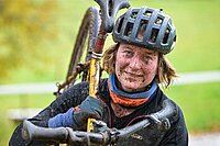 Eine Radfahrerin mit Dreck verspritztem Gesicht.