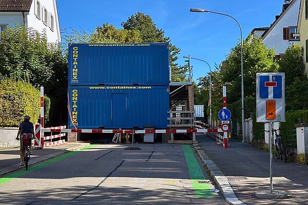 Blaue Baracken stehen auf einer Strasse.