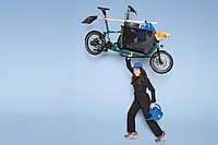 Eine Frau hebt ein Fahrrad in die Luft