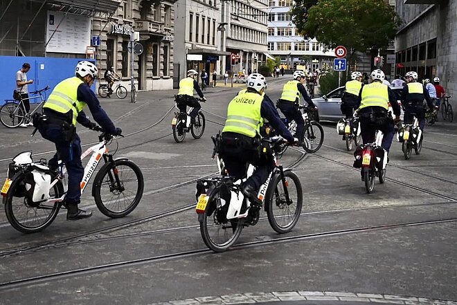 August 2023: Mehr Polizei als «kritische Einzelteile» an der Critical Mass in Zürich. Repression an der Critical Mass in Zürich. Polizisten in Leuchtwesten fahren auf E-Bikes in der Stadt Zürich.