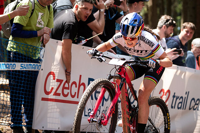 Eine Frau fährt ein Cross Country Rennen auf einem Mountainbike von Scott.