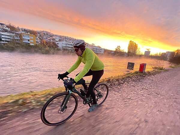 Winter Gravelbike Zürich nach Bern. Gravelbiker an einem Flussufer.