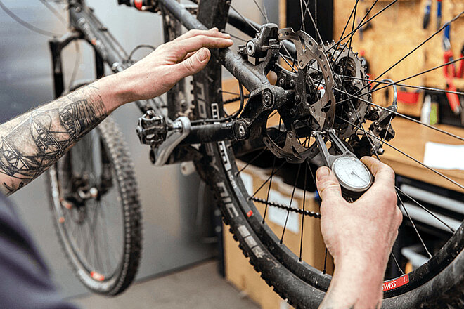 Einstiegskurs für Velowerkstatt-Mitarbeitende. Neue Daten verfügbar. Eine Person misst die Dicke einer Bremsscheibe am Fahrrad.