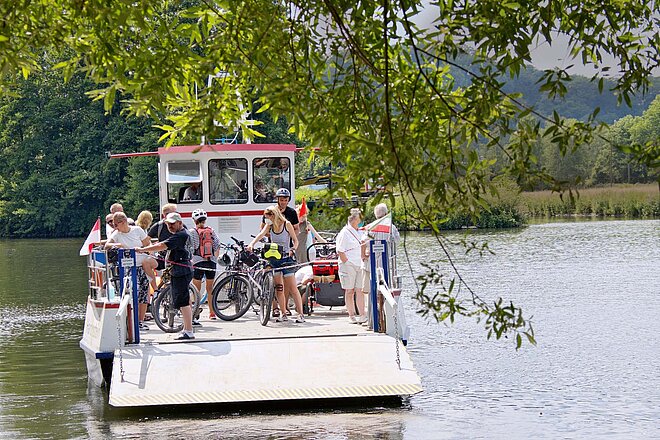 Einmal übersetzen, bitte: Kurz vor der Zeche Nachtigall geht es mit der Ruhrtalfähre auf die andere Seite des Flusses. Fahrradtour im Radrevier Ruhr. Eine Fähre bringt Personen über einen Fluss.
